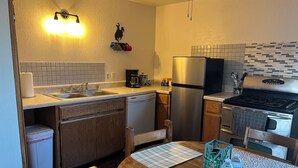 A modern kitchen with a dishwasher, refrigerator, stove, and a coffee maker. - Cozy 1-bedroom studio in charming Grants perfect for your getaway (Grants)