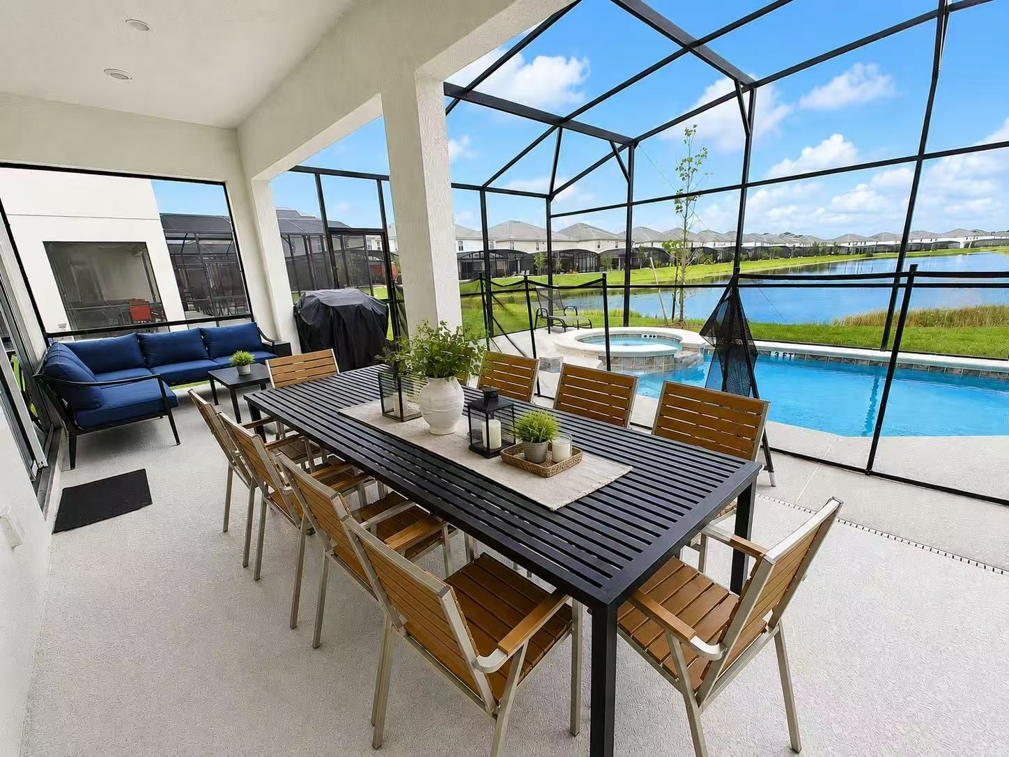 An outdoor dining area with a view of a swimming pool and mountains.