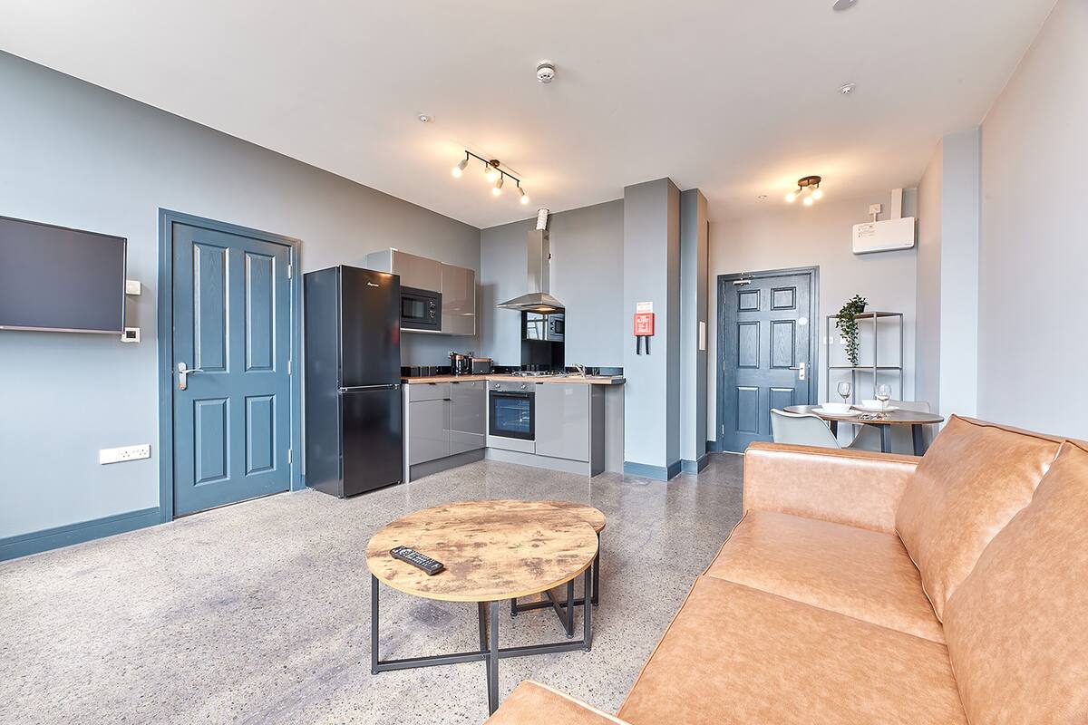 A modern apartment with a kitchen, dining area, and living room.