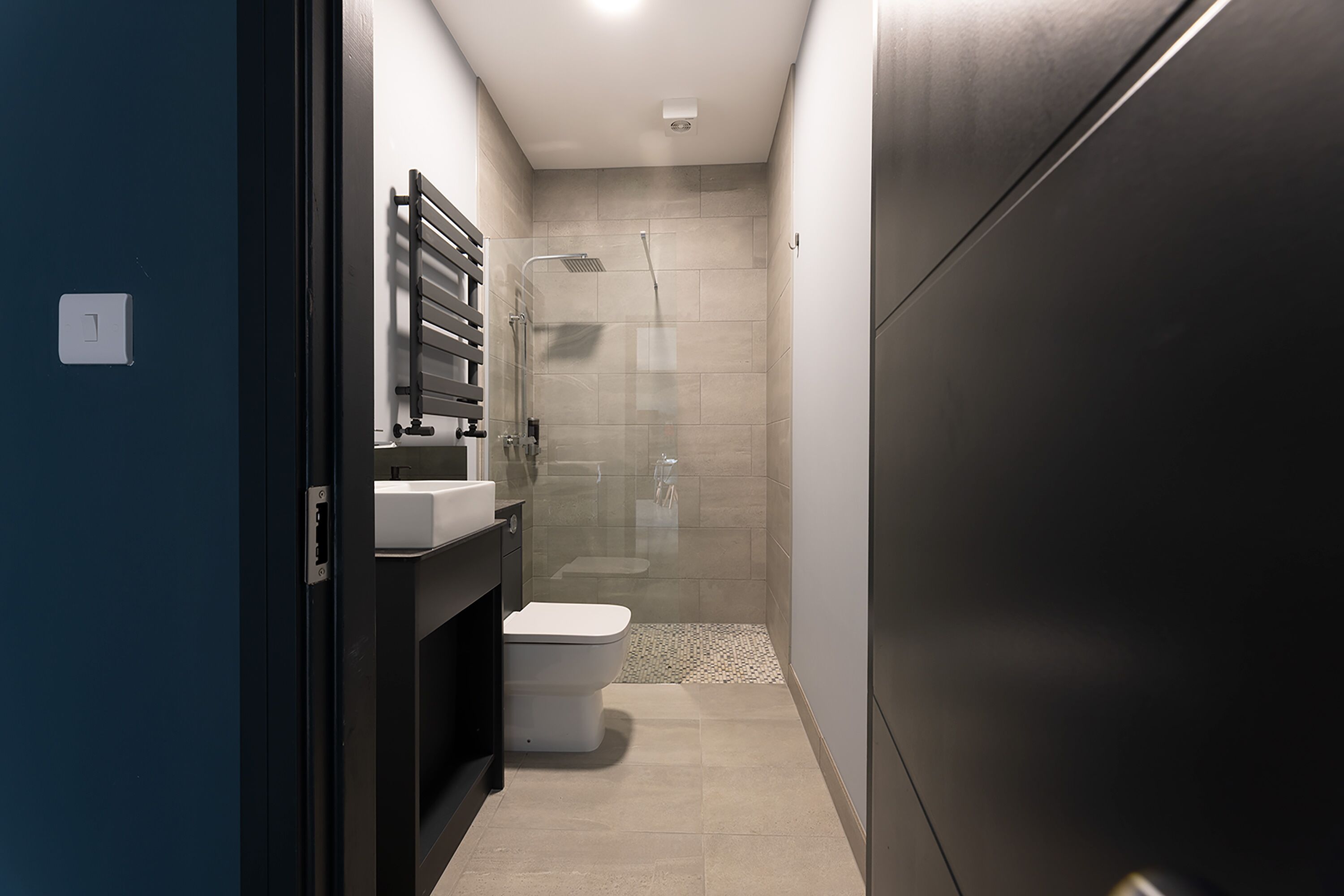 A modern bathroom with a shower, toilet, and sink.