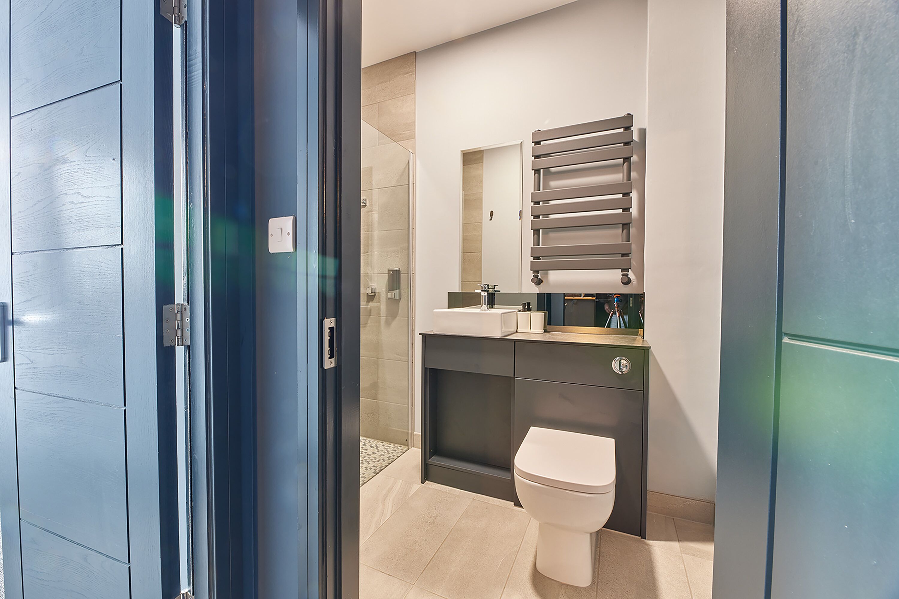 A modern bathroom with a toilet, sink, and shower.