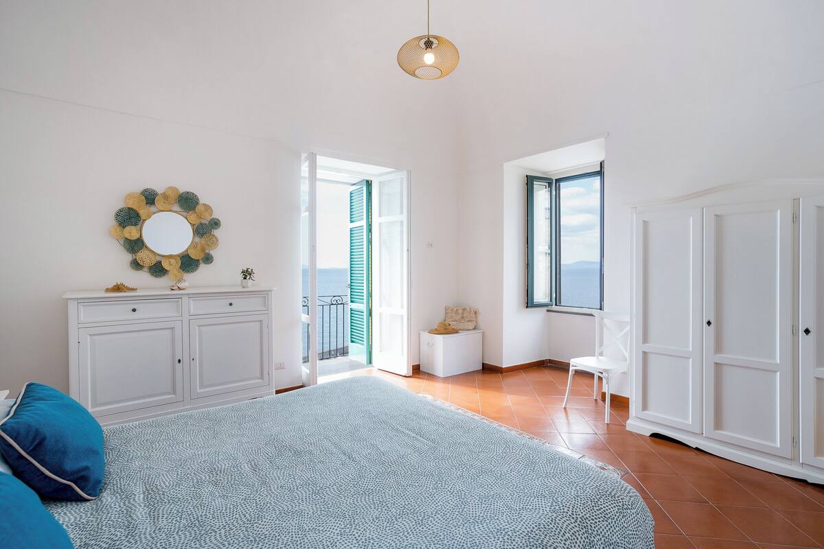 Une chambre spacieuse avec un grand lit, une armoire et une fenêtre donnant sur un beau paysage.