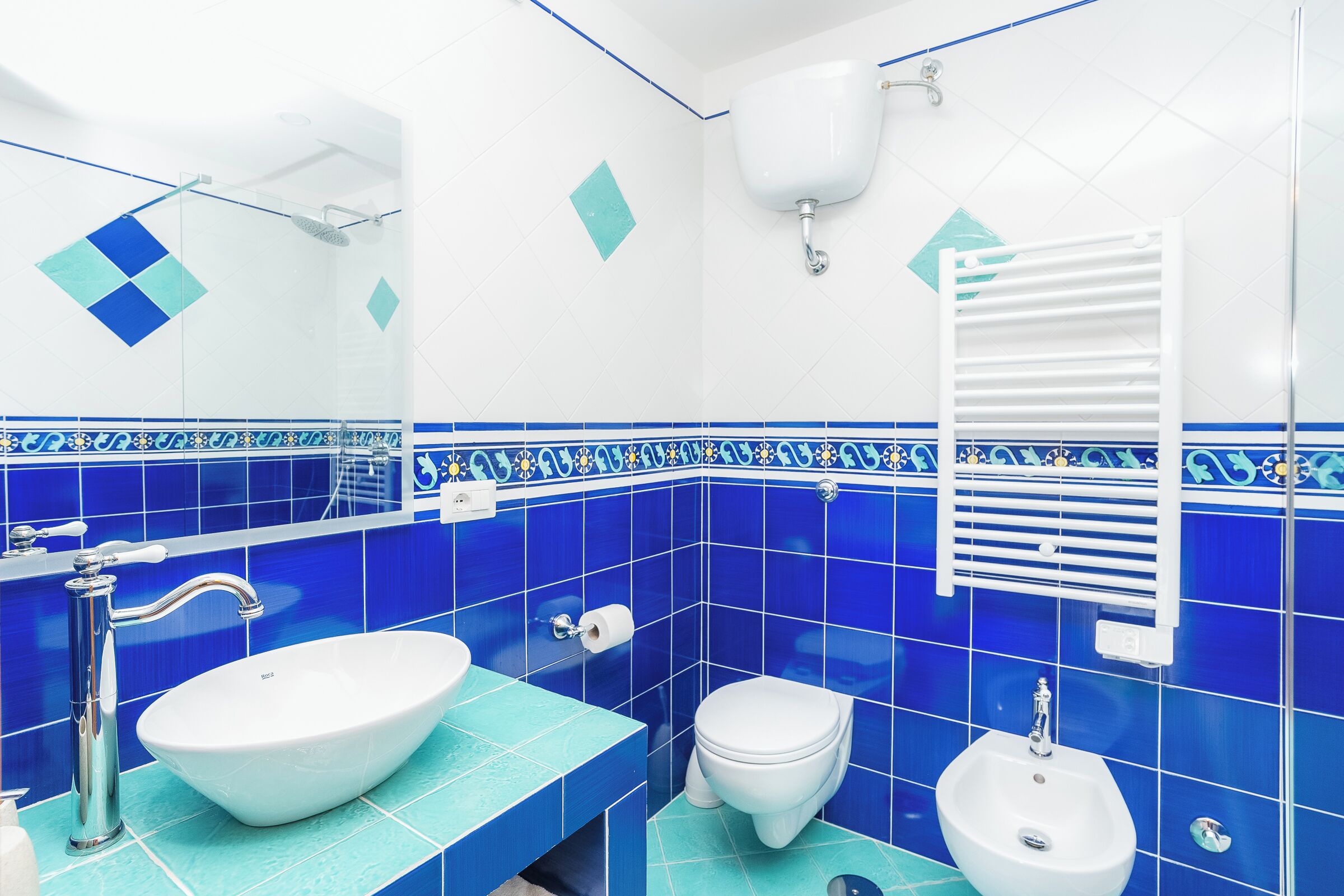 Ein Badezimmer mit einem weißen Waschbecken, einer Toilette und einem Bidet.