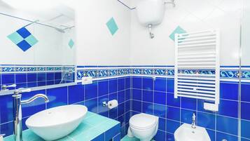 Ein Badezimmer mit einem weißen Waschbecken, einer Toilette und einem Bidet.