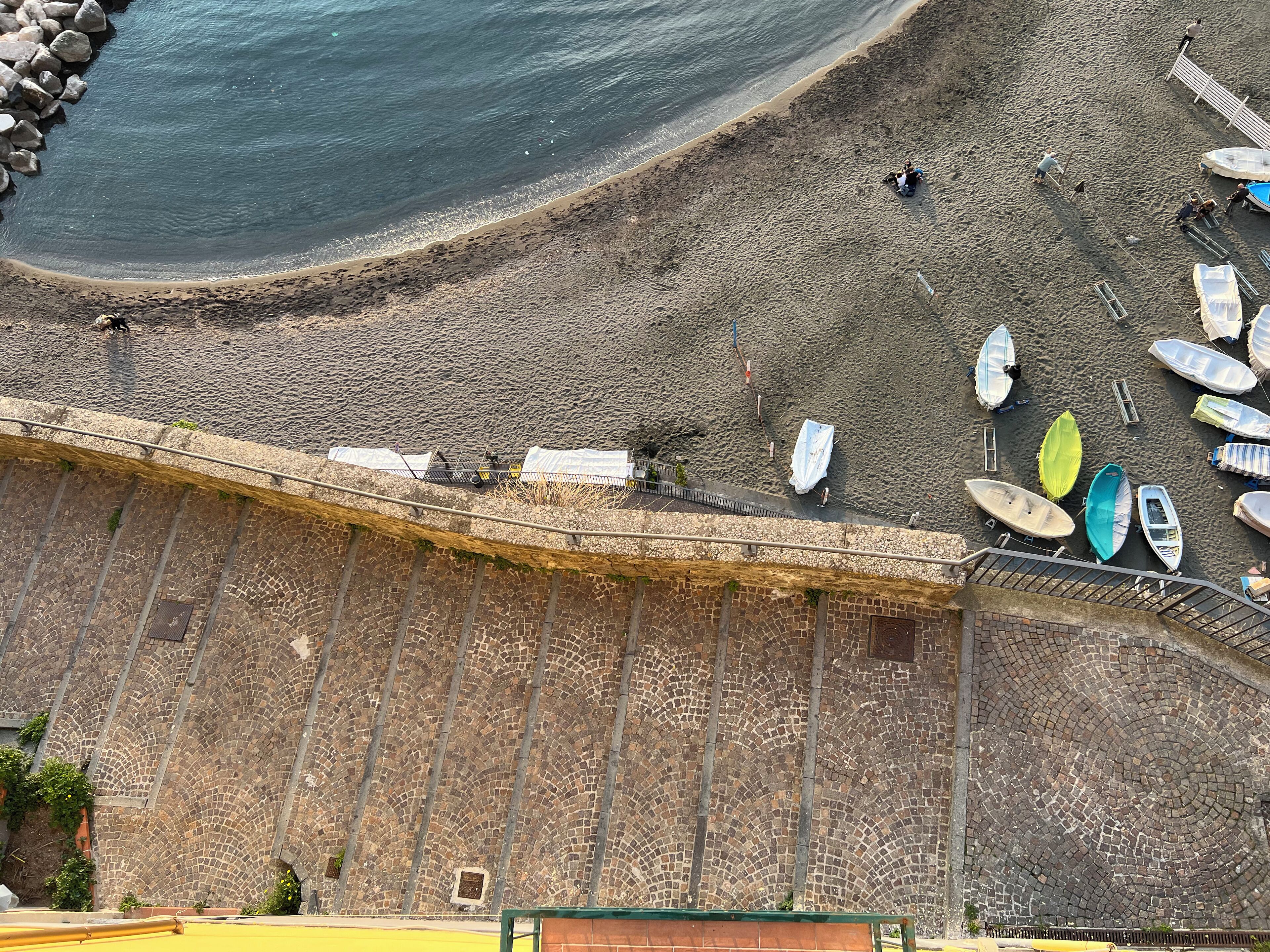 Una spiaggia con barche e persone.
