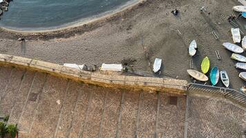 Una spiaggia con barche e persone.