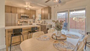 A modern kitchen with wooden cabinets, stainless steel appliances, and a central island with seating. - Charming Townhouse in Tucson. (Tucson)