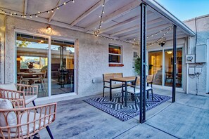 An outdoor patio area with a table and chairs, string lights, and a patterned rug. - Charming Townhouse in Tucson. (Tucson)