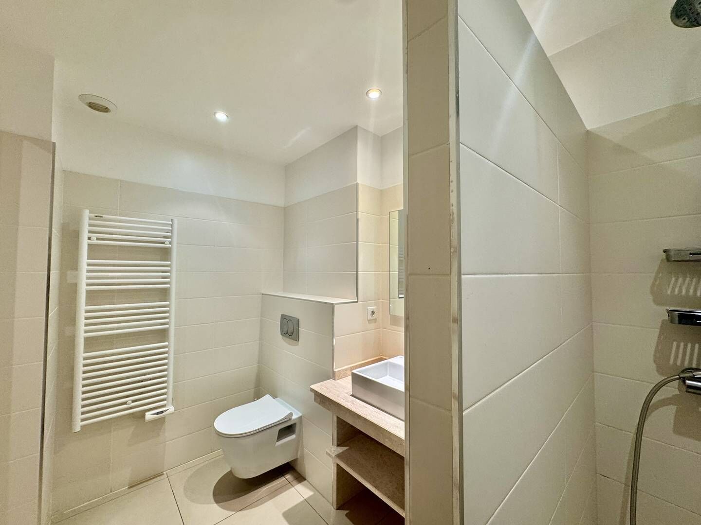 A modern bathroom with a toilet, sink, and shower.