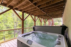 A hot tub under a wooden deck with a view of trees. - Welcome to Our Happy Nest - Pet friendly, hot tub, game tables (Boone)