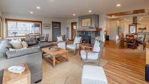 A spacious living room with a fireplace, a dining area, and a kitchen. - Seaside Oceanfront on the Prom | 5BR, Sweeping Views, and Direct Access to the Seaside Promenade (Seaside)