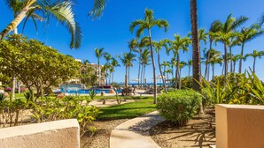 Ein Resort mit Poolanlage, Palmen und blauem Himmel.