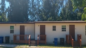 A row of single-story cabins with wooden railings and steps leading to the doors. - GpL 2670 Downtown Family get away (Fort Myers)