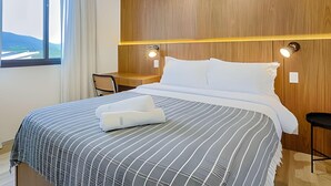Ein Hotelzimmer mit Bett, Schreibtisch und Stuhl.