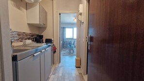 Une petite cuisine équipée d’un réfrigérateur, d’une cuisinière et de placards.