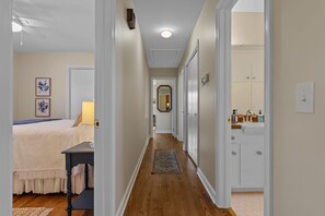 A hallway with a bed, a desk, a rug, and a bathroom with cabinets and a sink. - 3-bedroom Furnished One-level home in beautiful Travelers Rest-Mountain views (Travelers Rest)