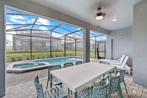 A covered outdoor area with a pool, seating, and a view of neighboring houses. - 2207LC- Spacious 7-bedroom home in Davenport, perfect for large groups near attractions! (Davenport)