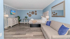 Un dormitorio con cama, mesita de noche, lámpara y espejo.