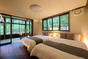 Habitación de hotel con dos camas, ventanas amplias, una lámpara de techo y un aire acondicionado instalado en la pared.