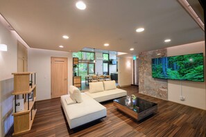 Biệt thự tiện nghi đơn giản, ban công, quang cảnh vườn | Khu phòng khách | Smart TV 75-inch có truyền hình kỹ thuật số 