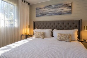 A hotel room with a large bed, a headboard, and a painting on the wall. - Starfish Beach Vacation Villa by Golden Coast Rentals (Indian Rocks Beach)