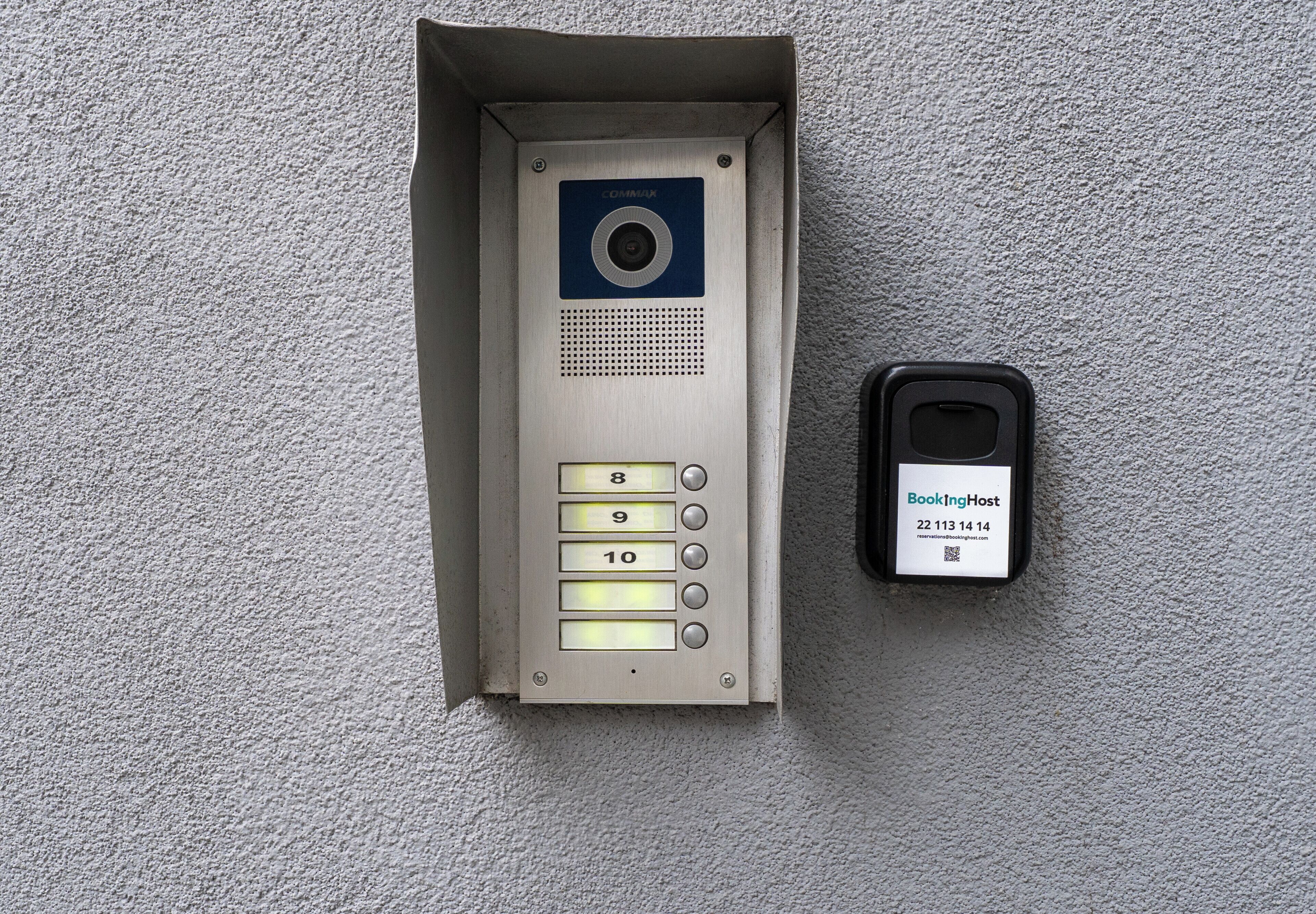 A wall-mounted intercom system with a keypad and a card reader.