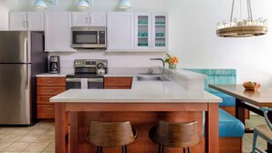 A modern kitchen with white cabinets, stainless steel appliances, and a central island with stools. - Resort Getaway Ideal for Families, Disney Trips & Relaxation (Orlando)