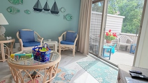 A room with wicker furniture, a glass table, and a view of the outdoors. - 222 Mariner's Court - Steps from the Boardwalk, Beach, Dining & Everything Rehoboth Has to Offer! (Rehoboth Beach)