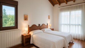 Un dormitorio con dos camas, una ventana que ofrece vistas a la vegetación y un techo de madera.