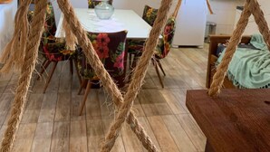 Uma sala de jantar com uma mesa posta para quatro pessoas, rodeada por cadeiras com padrão floral.