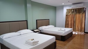 A hotel room with two beds, a nightstand, a window with curtains, and a wooden floor. - Asia Jem Hotel - Bacolod City (Bacolod)