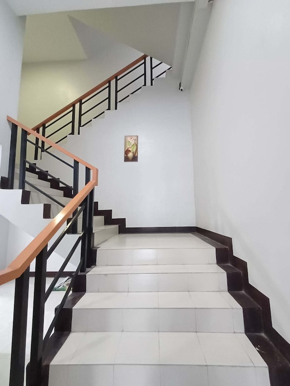 A staircase with white steps and black edges, leading to an upper floor.