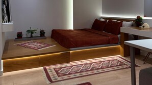 Un dormitorio moderno con cama, mesita de noche y escritorio.