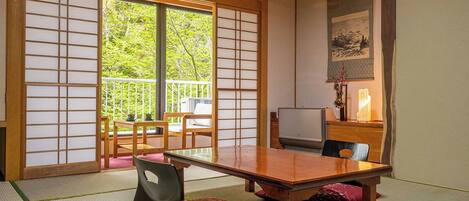 Una habitación japonesa tradicional con suelo de tatami, una mesa de madera baja y puertas correderas.