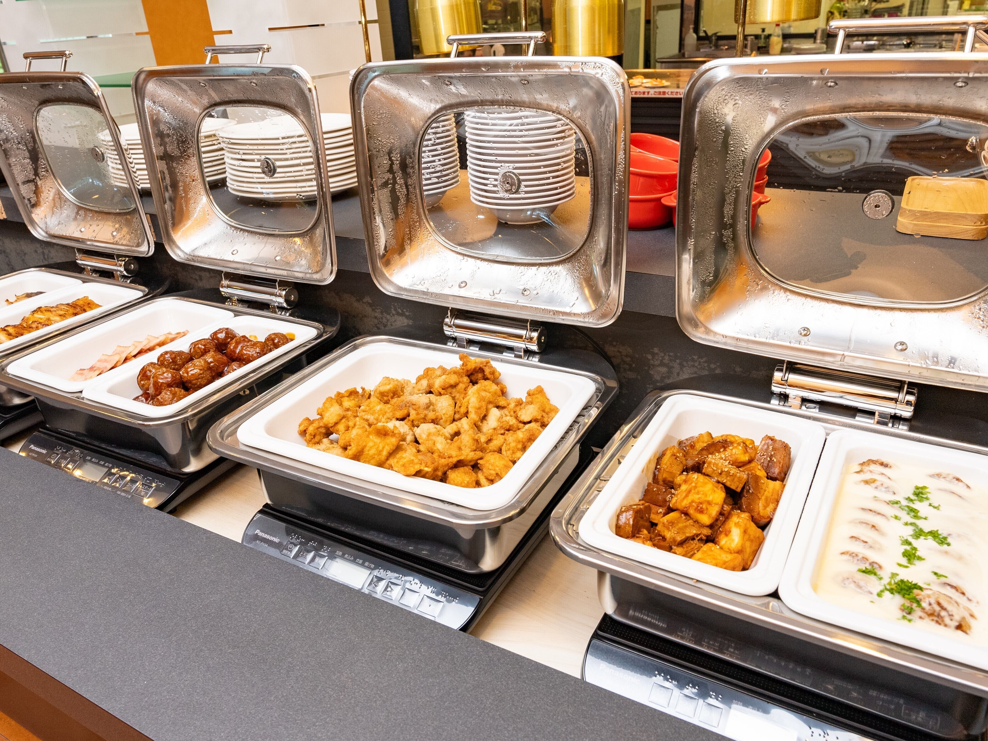 Een buffet met diverse gerechten in metalen bakken.