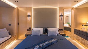 Quarto moderno com uma cama grande, mesas de cabeceira, um espelho e um guarda-roupa embutido.