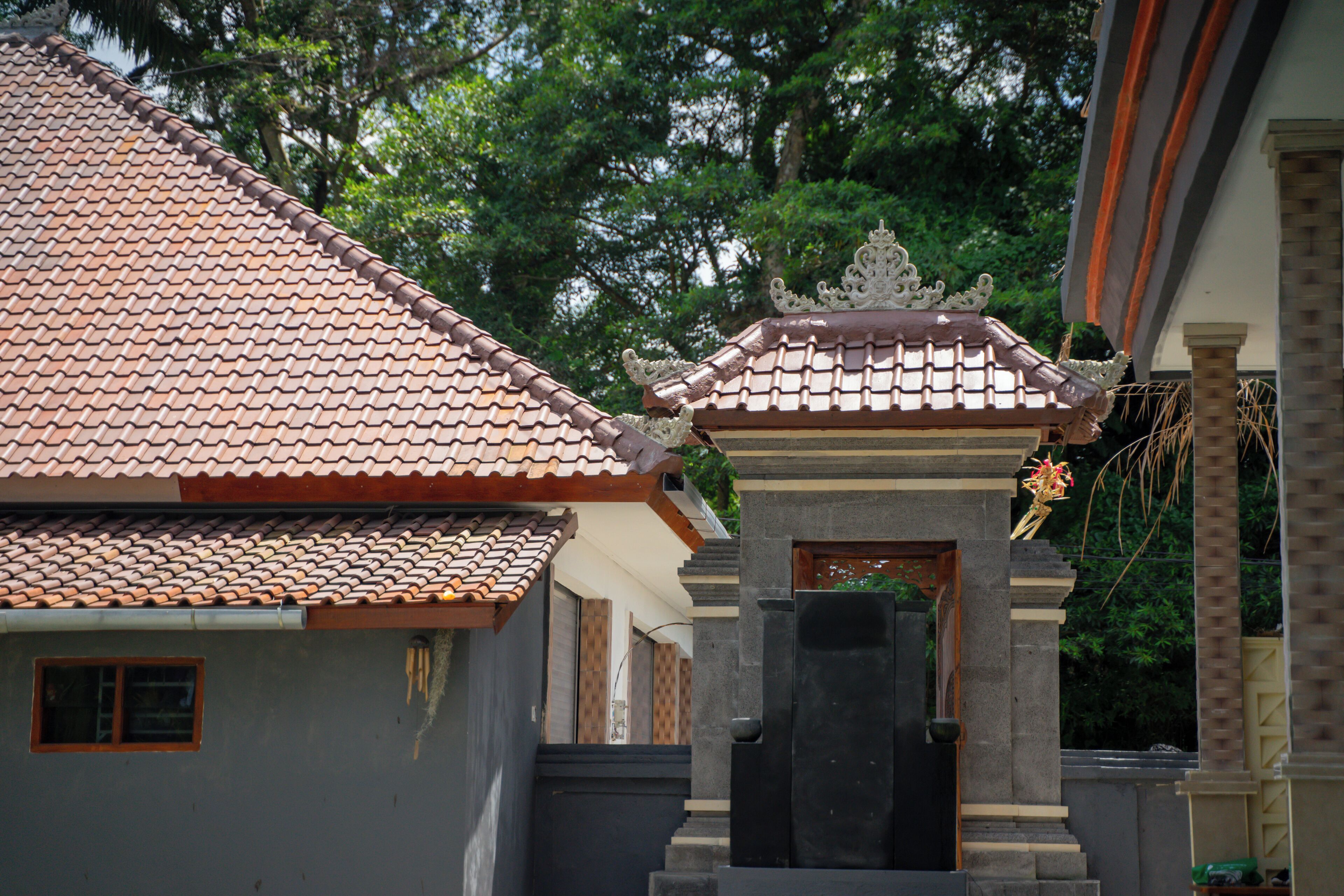 A traditional building with a tiled roof and a central entrance with a decorative gate.
