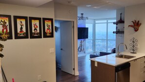 A modern kitchen with a large window, a built-in dishwasher, and a small island. - Luxury Condo Toronto YYZ (Toronto)