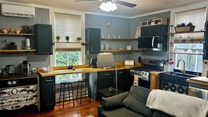 A compact kitchen with a central island, a dining area with a sofa, and a ceiling fan. - Historic Downtown Apt with hot tub-walk downtown (Ocala)