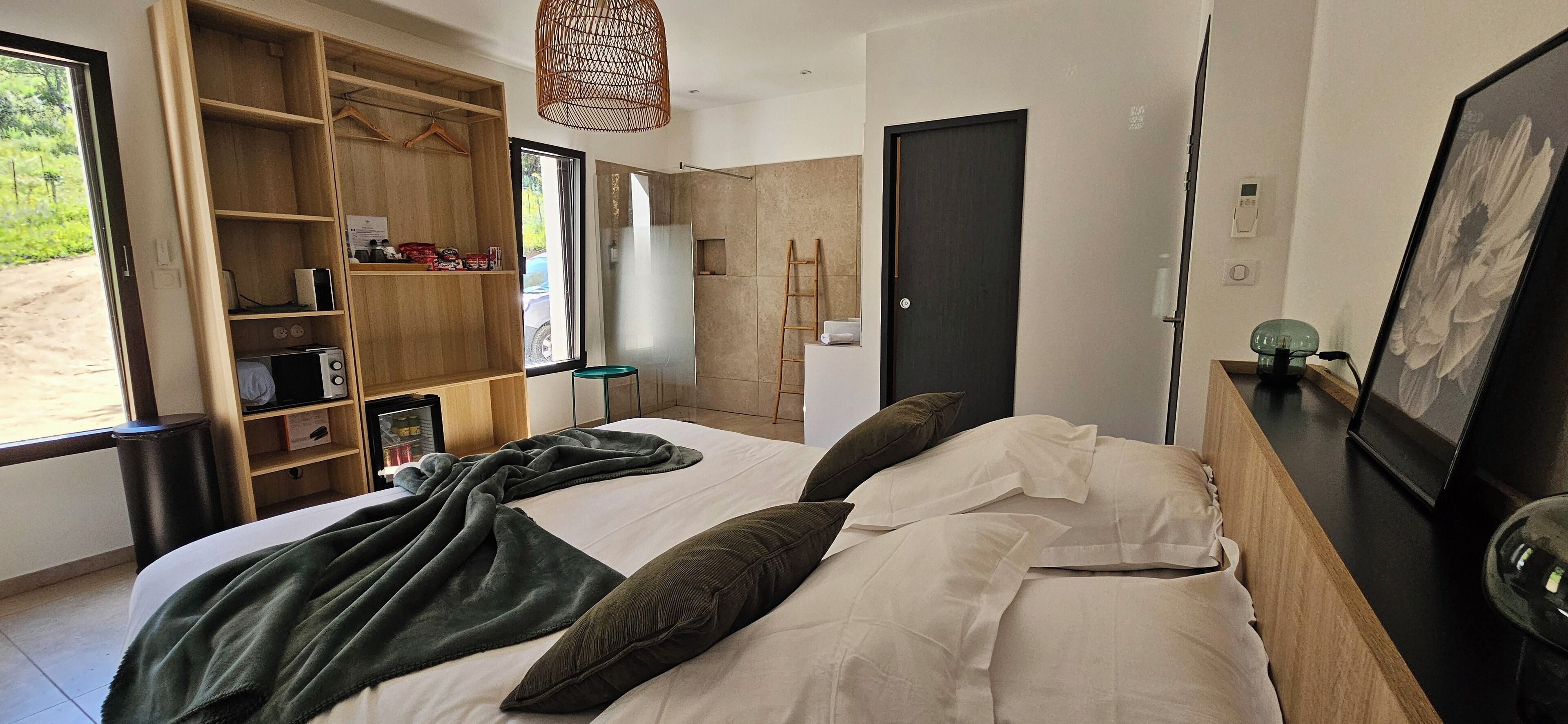 Un dormitorio moderno con una cama grande, un armario de madera, un escritorio y vistas al exterior.
