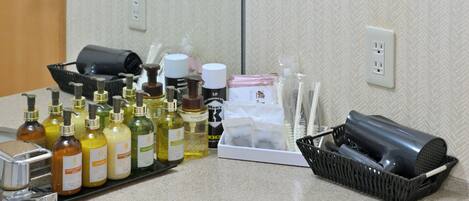 Una encimera de baño con diversos artículos de aseo y productos para el cabello.