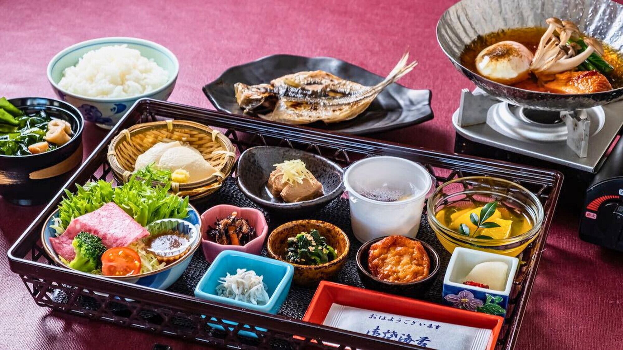 Una comida tradicional japonesa con diversos platos y un caldo caliente.