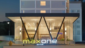 A modern building with a glass facade and a sign reading "maxone batam". - MAXONE Batam (Batam)