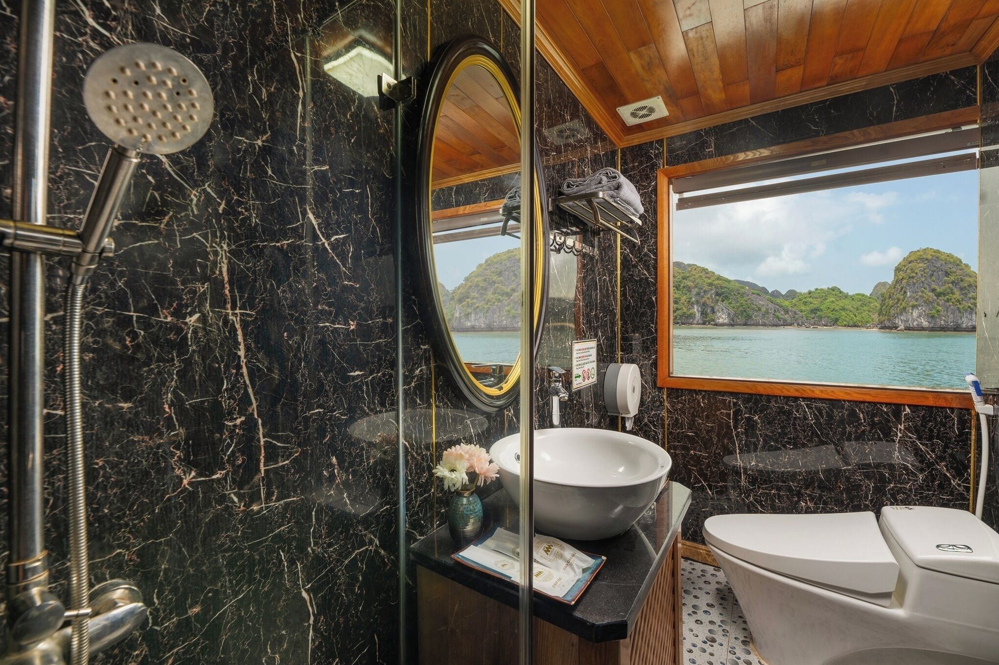 A bathroom with a large mirror, a sink, and a toilet.