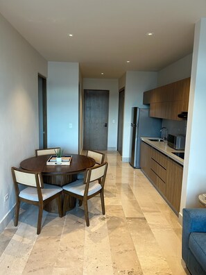 A modern kitchen with wooden cabinets, a built-in microwave, and a stainless steel refrigerator. - Brand New Condo In Beautiful Cozumel - 2 Bedroom/2 Bath With AC and Fitness Room (San Miguel de Cozumel)