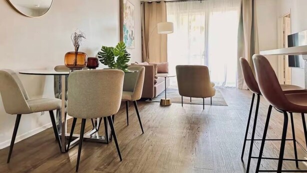 A modern dining area with a round table, four chairs, and a potted plant. - Luxe Marina Escape-Near SoFi & Beaches (Marina del Rey)