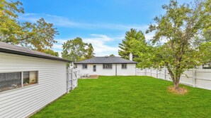 A single-story house with a well-maintained lawn and a wooden fence. - Spacious 5-bedroom house in beautiful Downers Grove (Downers Grove)