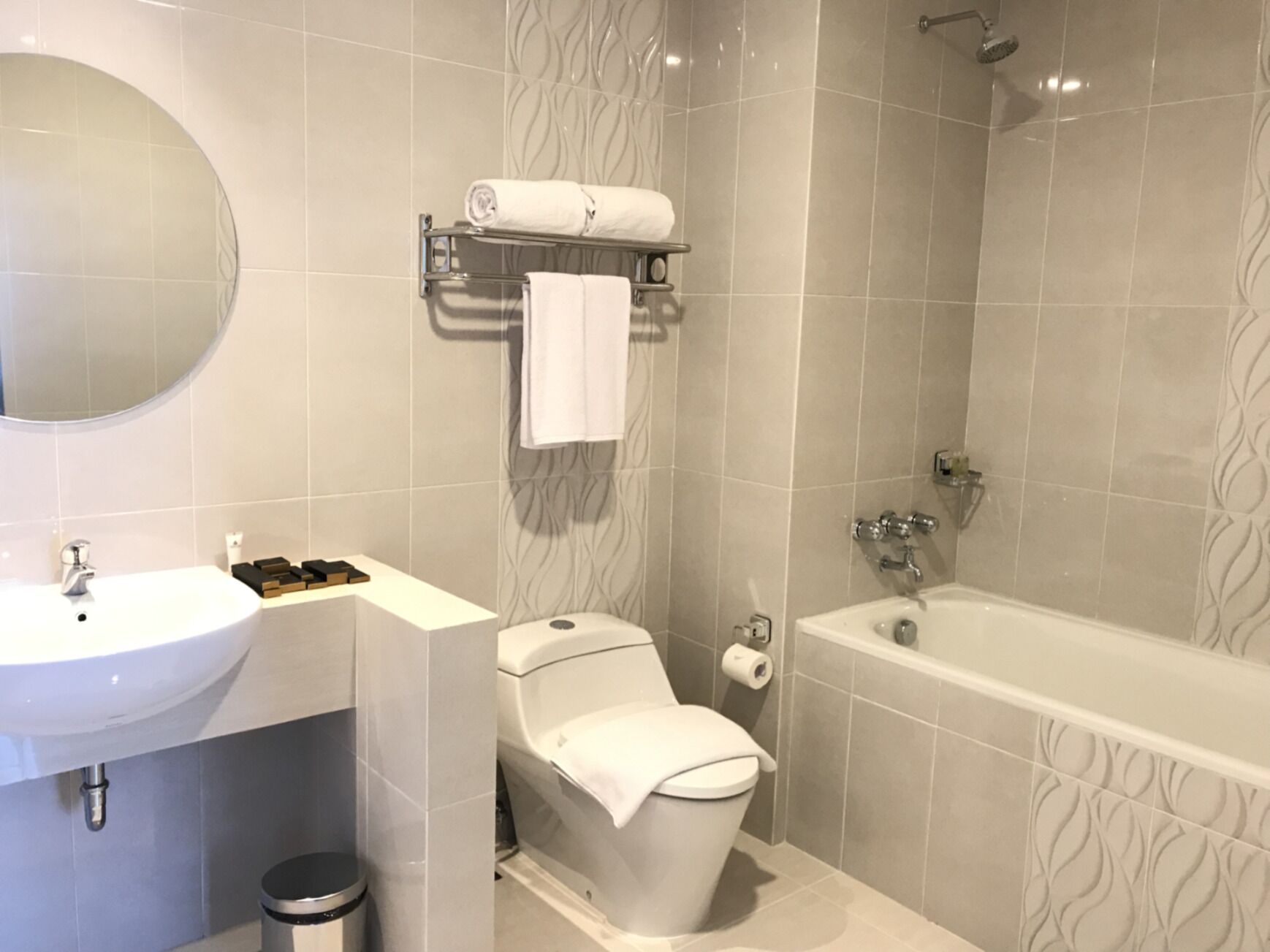 Un baño moderno con lavamanos, inodoro y bañera blancos.