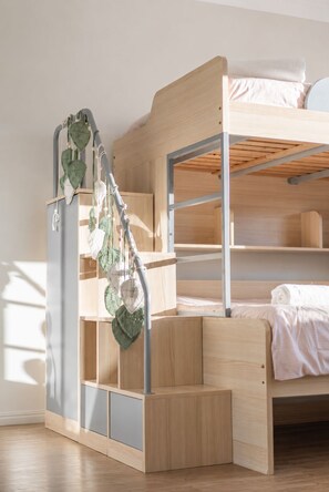 A bunk bed with a metal ladder and a small shelf unit.