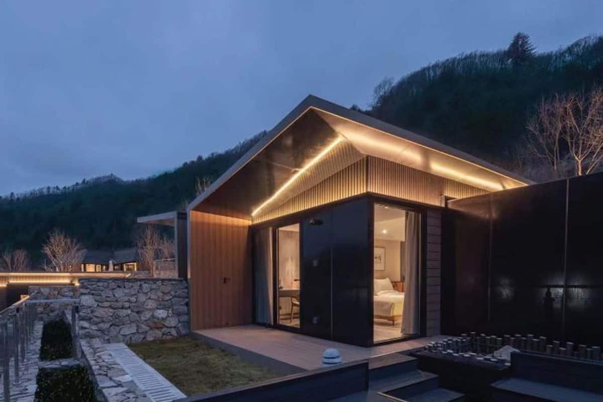 Une maison moderne avec un chemin de pierre menant à une terrasse en bois.